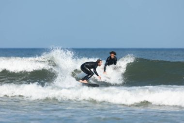 Deal, New Jersey - 10 Ağustos 2024: sörfçüler Debby Kasırgası 'nın kalıntılarında Deal açıklarında sörf yapıyor.