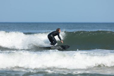 Deal, New Jersey - 10 Ağustos 2024: sörfçüler Debby Kasırgası 'nın kalıntılarında Deal açıklarında sörf yapıyor.