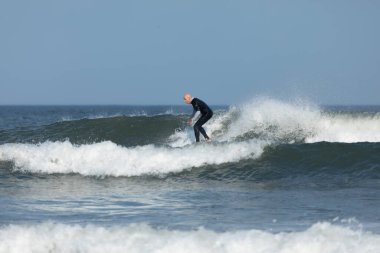 Deal, New Jersey - 10 Ağustos 2024: sörfçüler Debby Kasırgası 'nın kalıntılarında Deal açıklarında sörf yapıyor.