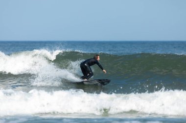 Deal, New Jersey - 10 Ağustos 2024: sörfçüler Debby Kasırgası 'nın kalıntılarında Deal açıklarında sörf yapıyor.