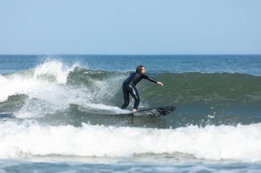 Deal, New Jersey - 10 Ağustos 2024: sörfçüler Debby Kasırgası 'nın kalıntılarında Deal açıklarında sörf yapıyor.