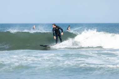 Deal, New Jersey - 10 Ağustos 2024: sörfçüler Debby Kasırgası 'nın kalıntılarında Deal açıklarında sörf yapıyor.