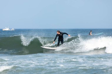 Deal, New Jersey - 10 Ağustos 2024: sörfçüler Debby Kasırgası 'nın kalıntılarında Deal açıklarında sörf yapıyor.