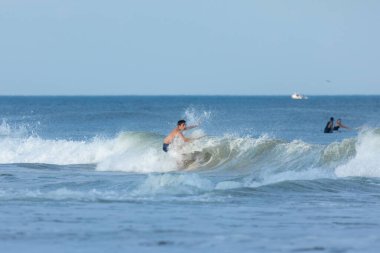 Deal, New Jersey - 10 Ağustos 2024: sörfçüler Debby Kasırgası 'nın kalıntılarında Deal açıklarında sörf yapıyor.