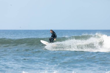 Deal, New Jersey - 10 Ağustos 2024: sörfçüler Debby Kasırgası 'nın kalıntılarında Deal açıklarında sörf yapıyor.