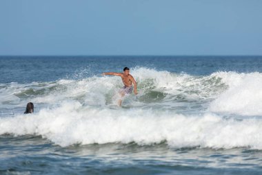 Deal, New Jersey - August 10, 2024: surfers surf the remnants of Hurricane Debby in the waters off Deal clipart