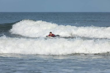 Deal, New Jersey - 10 Ağustos 2024: sörfçüler Debby Kasırgası 'nın kalıntılarında Deal açıklarında sörf yapıyor.