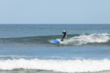 Deal, New Jersey - 10 Ağustos 2024: sörfçüler Debby Kasırgası 'nın kalıntılarında Deal açıklarında sörf yapıyor.