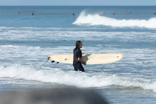 stock image Deal, New Jersey - August 10, 2024: surfers surf the remnants of Hurricane Debby in the waters off Deal