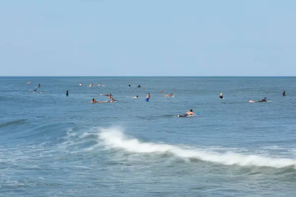 stock image Deal, New Jersey - August 10, 2024: surfers surf the remnants of Hurricane Debby in the waters off Deal