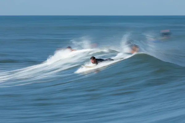 stock image Deal, New Jersey - August 10, 2024: surfers surf the remnants of Hurricane Debby in the waters off Deal