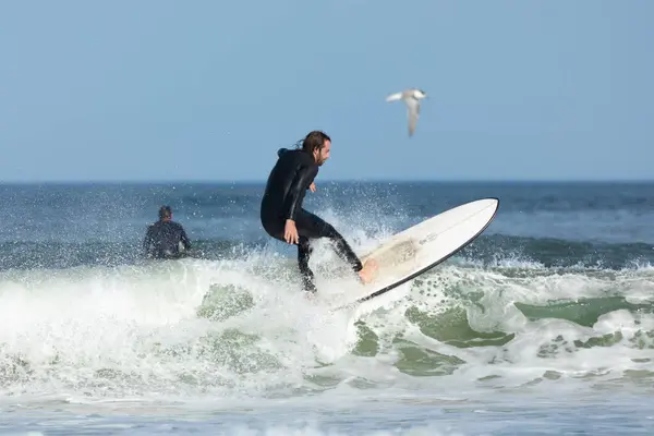 stock image Deal, New Jersey - August 10, 2024: surfers surf the remnants of Hurricane Debby in the waters off Deal