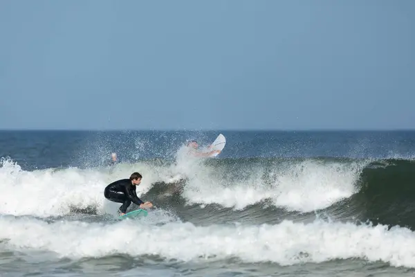 Stock image Deal, New Jersey - August 10, 2024: surfers surf the remnants of Hurricane Debby in the waters off Deal