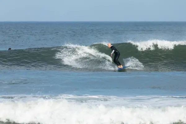 stock image Deal, New Jersey - August 10, 2024: surfers surf the remnants of Hurricane Debby in the waters off Deal