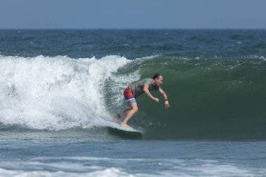 Deal, New Jersey - 18 Ağustos 2024: Sörfçüler Ernesto Kasırgası 'nın kalıntılarında sörf yapmak için Deal' da suyu dolduruyorlar