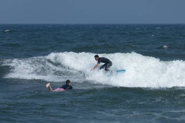 Deal, New Jersey - 18 Ağustos 2024: Sörfçüler Ernesto Kasırgası 'nın kalıntılarında sörf yapmak için Deal' da suyu dolduruyorlar