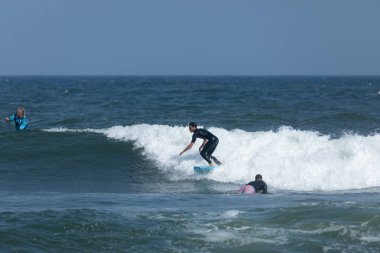 Deal, New Jersey - 18 Ağustos 2024: Sörfçüler Ernesto Kasırgası 'nın kalıntılarında sörf yapmak için Deal' da suyu dolduruyorlar