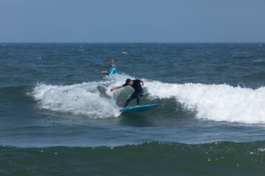 Deal, New Jersey - 18 Ağustos 2024: Sörfçüler Ernesto Kasırgası 'nın kalıntılarında sörf yapmak için Deal' da suyu dolduruyorlar