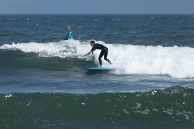 Deal, New Jersey - 18 Ağustos 2024: Sörfçüler Ernesto Kasırgası 'nın kalıntılarında sörf yapmak için Deal' da suyu dolduruyorlar