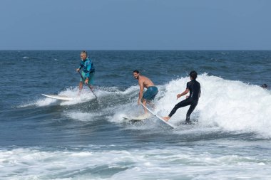 Deal, New Jersey - 18 Ağustos 2024: Sörfçüler Ernesto Kasırgası 'nın kalıntılarında sörf yapmak için Deal' da suyu dolduruyorlar