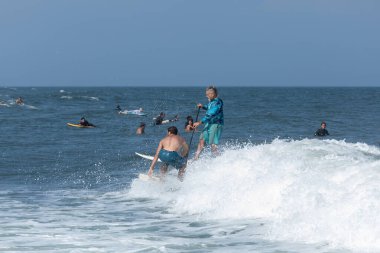 Deal, New Jersey - 18 Ağustos 2024: Sörfçüler Ernesto Kasırgası 'nın kalıntılarında sörf yapmak için Deal' da suyu dolduruyorlar