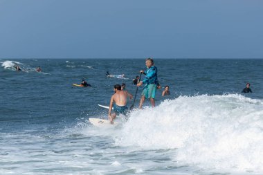 Deal, New Jersey - 18 Ağustos 2024: Sörfçüler Ernesto Kasırgası 'nın kalıntılarında sörf yapmak için Deal' da suyu dolduruyorlar