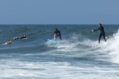Deal, New Jersey - 18 Ağustos 2024: Sörfçüler Ernesto Kasırgası 'nın kalıntılarında sörf yapmak için Deal' da suyu dolduruyorlar