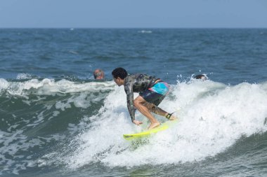 Deal, New Jersey - 18 Ağustos 2024: Sörfçüler Ernesto Kasırgası 'nın kalıntılarında sörf yapmak için Deal' da suyu dolduruyorlar