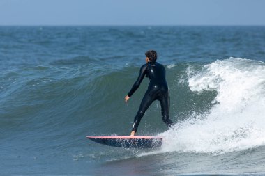 Deal, New Jersey - 18 Ağustos 2024: Sörfçüler Ernesto Kasırgası 'nın kalıntılarında sörf yapmak için Deal' da suyu dolduruyorlar