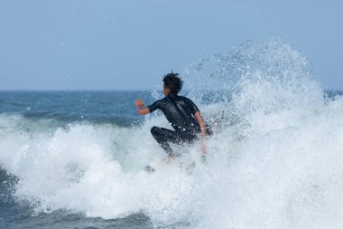 Deal, New Jersey - 18 Ağustos 2024: Sörfçüler Ernesto Kasırgası 'nın kalıntılarında sörf yapmak için Deal' da suyu dolduruyorlar