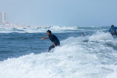 Deal, New Jersey - 18 Ağustos 2024: Sörfçüler Ernesto Kasırgası 'nın kalıntılarında sörf yapmak için Deal' da suyu dolduruyorlar