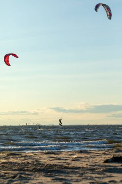 Sandy Hook, New Jersey - 21 Ağustos 2024: Kiteboardcular muhteşem bir yaz gecesinde Sandy Hook 'un üzerinde güneş batarken denize açılıyorlar