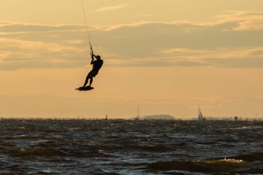 Sandy Hook, New Jersey - 21 Ağustos 2024: Kiteboardcular muhteşem bir yaz gecesinde Sandy Hook 'un üzerinde güneş batarken denize açılıyorlar