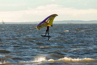 Sandy Hook, New Jersey - August 21, 2024: Kiteboarders take to the water as the sun sets over Sandy Hook on a gorgeous summer's night clipart