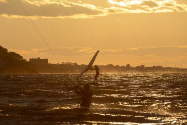 Sandy Hook, New Jersey - 21 Ağustos 2024: Kiteboardcular muhteşem bir yaz gecesinde Sandy Hook 'un üzerinde güneş batarken denize açılıyorlar
