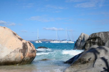 Virgin Gorda, Britanya Virgin Adaları - 27 Şubat 2006: Hamamlardaki kayaların ve kaya oluşumlarının manzarası. Yelkenliler arka planda demirli..