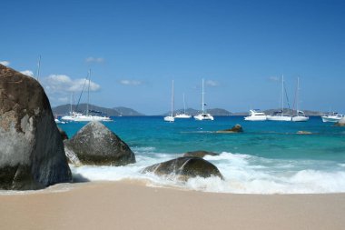 Virgin Gorda, Britanya Virgin Adaları - 27 Şubat 2006: Hamamlardaki kayaların ve kaya oluşumlarının manzarası. Yelkenliler arka planda demirli..