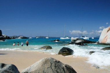 Virgin Gorda, Britanya Virgin Adaları - 27 Şubat 2006: Hamamlardaki kayaların ve kaya oluşumlarının manzarası. Yelkenliler arka planda demirli..
