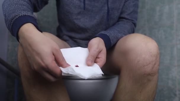 Концепция Геморроя Мужчина Сидит Унитазе Держит Руках Белую Туалетную Бумагу — стоковое видео