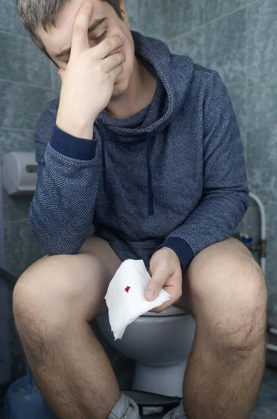 Koncepcja Hemoroidów Mężczyzna Siedzi Toalecie Trzyma Rękach Biały Papier Toaletowy — Zdjęcie stockowe