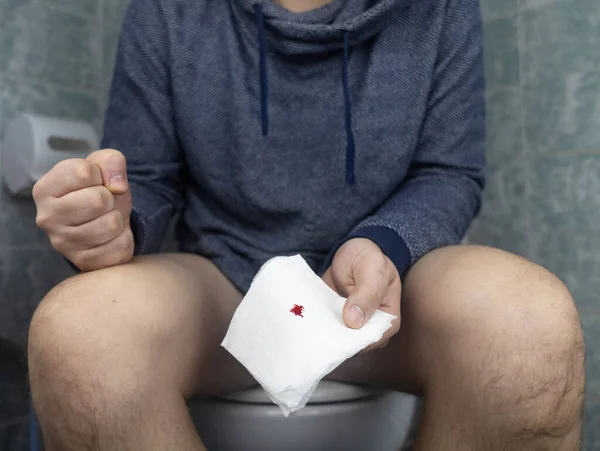 Hemorrhoid Concept Man Sits Toilet Holds White Toilet Paper His — Stock Photo, Image
