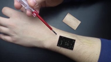 Robot arm concept. Man shows biomechanical prosthetic hand. Guy repairs his hand with tool. Bioengineering, transhumanism, biohacking, human cyborg. Fusion of electronics, mechanics and the human body