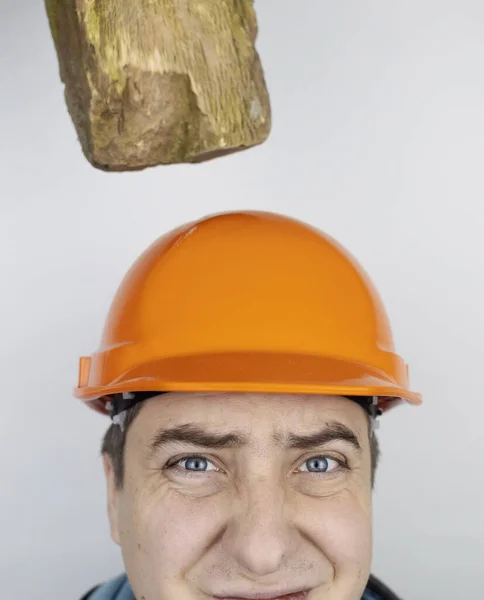 Safety helmet. Brick and a board fall on builder head. Saving a life due to wearing a protective construction helmet. Protection of worker from accidents. Falling objects from a height. Slow mo effect