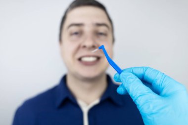 Interdental brush. A man shows a brush for cleaning the interdental space. Brush for cleaning teeth and daily oral care. Dentistry and orthodontics 