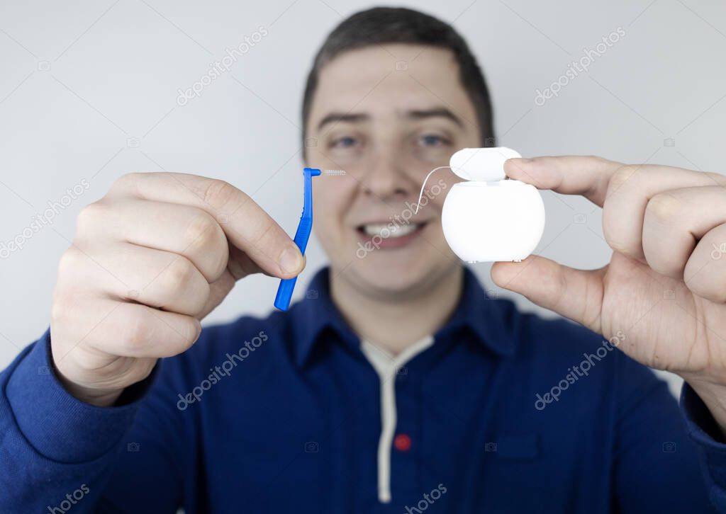 Interdental brush. A man shows a brush for cleaning the interdental space. Brush for cleaning