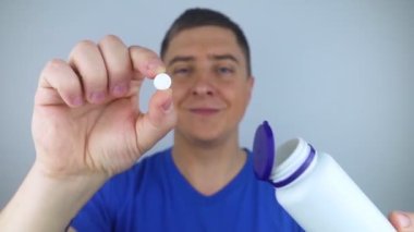 Oral probiyotikler. Bir adam, dilinde yararlı bakteri olan bir hap koyar. Ağızda disbakteriyoz ve yararlı ve zararlı mikroorganizmaların dengesizliği. Bağışıklığı artırın ve sağlığınızı iyileştirin.