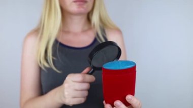 Antiperspirant containing aluminum chloride. Sweat gland blocker. Deodorant containing toxic agent. Aluminum chlorohydrate, alcohol, parabens, propylene glycol. Girl applying antiperspirant her armpit