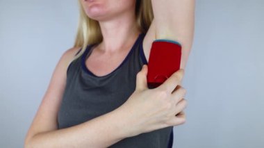 Antiperspirant containing aluminum chloride. Sweat gland blocker. Deodorant containing toxic agent. Aluminum chlorohydrate, alcohol, parabens, propylene glycol. Girl applying antiperspirant her armpit