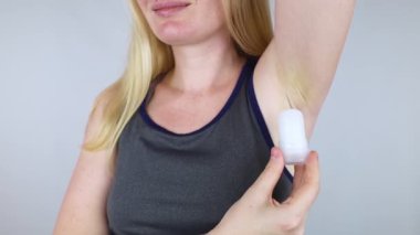 Mineral alum crystal stick. A woman applies a natural antiperspirant to her armpits to reduce odor and sweat. Natural environmentally friendly and safe cosmetics. Safe for people