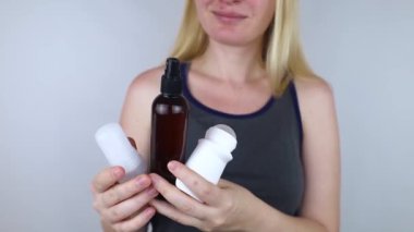 Girl holds in her hands three eco-friendly antiperspirants with natural ingredients. Refusal of antiperspirants containing toxic substances. Freedom from Aluminum chlorohydrate, alcohol, parabens